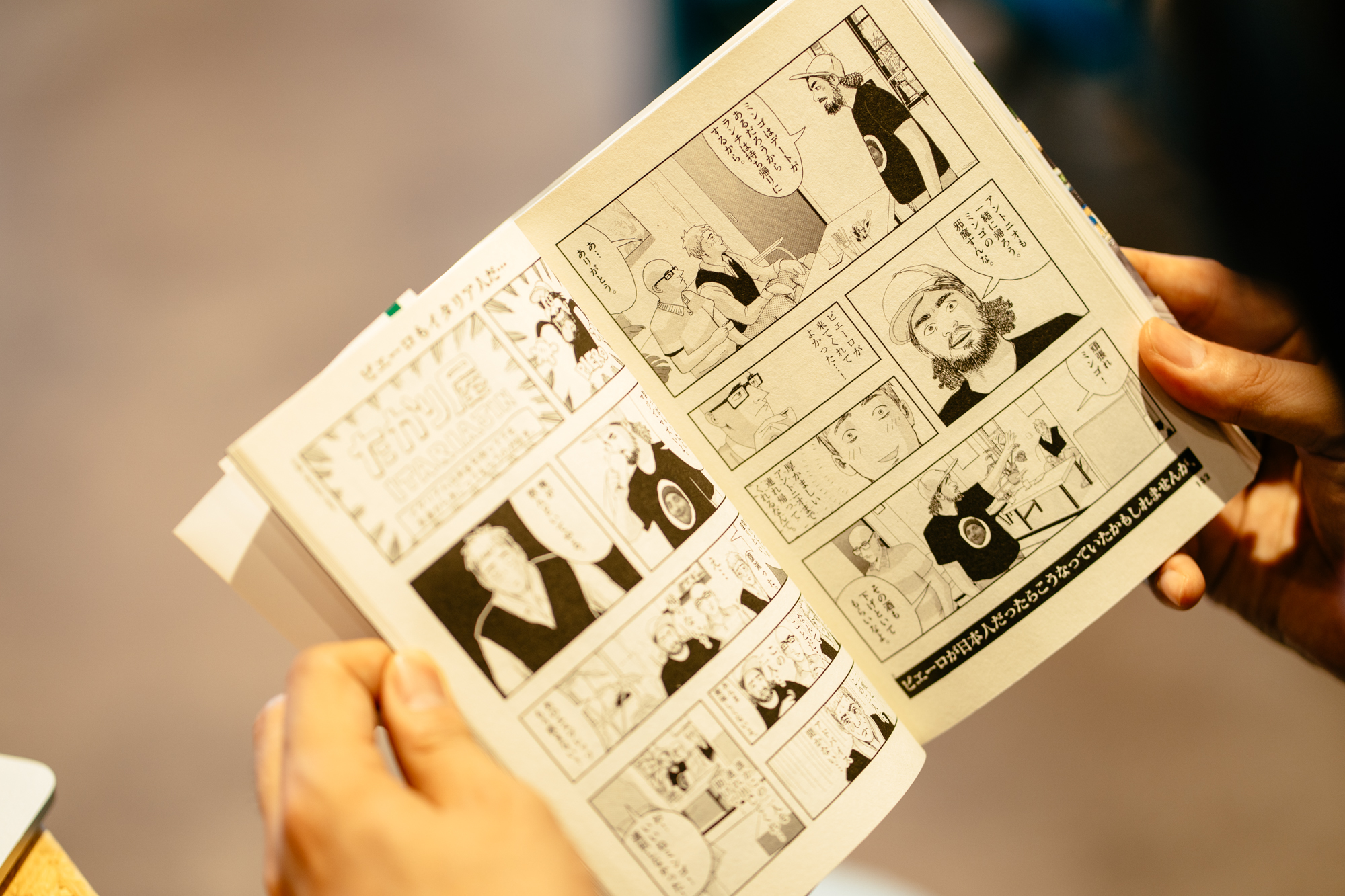 Peppe holding an open copy of his manga Mingo